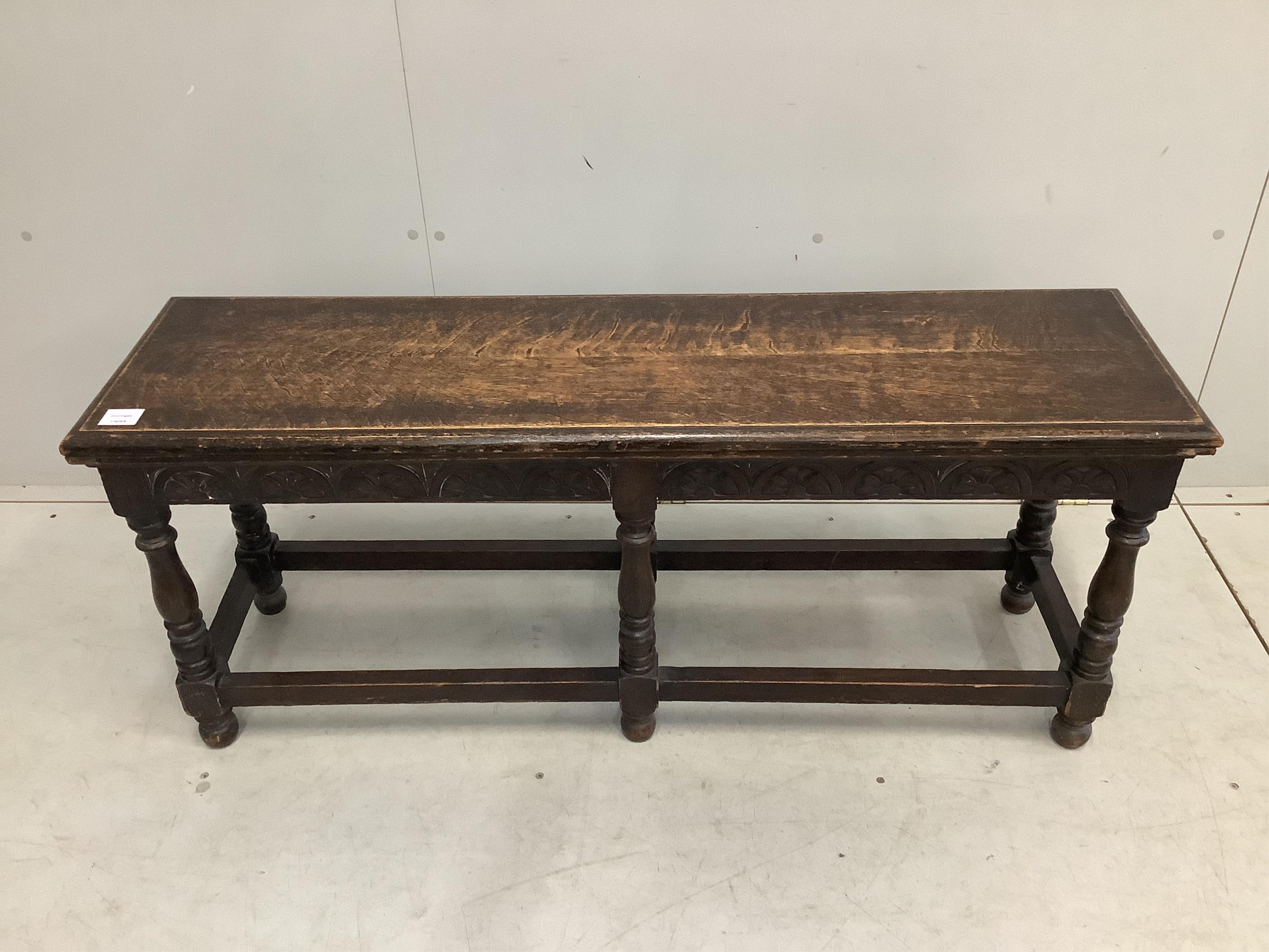An early 20th century Jacobean Revival oak window seat, width 122cm, depth 34cm, height 51cm. Condition - fair